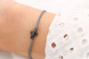 graues Kreuz Armband Schwarz rhodiniert am Handgelenk getragen und verstellbarem Verschluss