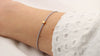 Video graues Lederarmband mit einer quadratischen Perle in rosegold und Schiebeschließe am Handgelenk getragen
