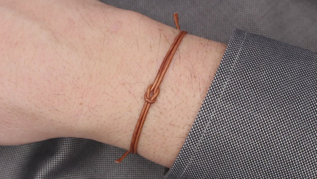 Tragevideo des hell braunes Lederarmband Infinityknoten am Handgelenk des Mannes getragen