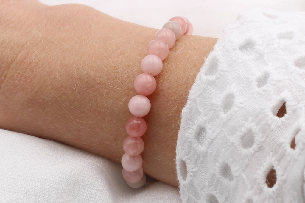 Perlenarmband mit rosa Natursteinperlen und Makramee Verschluss am Handgelenk der Dame getragen
