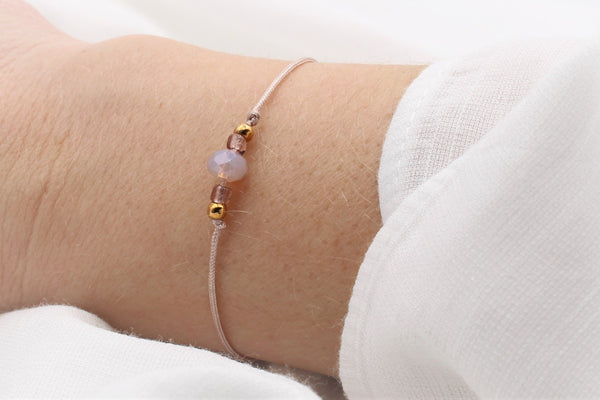 schlichtes Armband mit Facetten Perle in  Rosenholz und rosegold, silber oder goldfarbenen kleinen Perlen am Handgelenk getragen