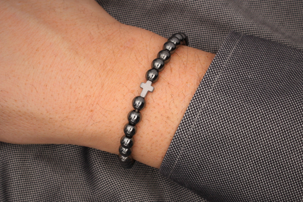 Herren Armband Kreuz in silberfarben und Perlen in anthrazit schwarz am Handgelenk des Mannes  getragen