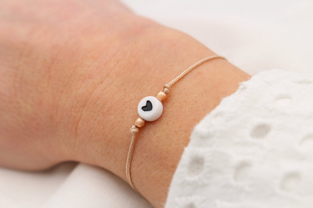 Schiebeknoten Armband  mit weißer Herz Perle am Handgelenk getragen