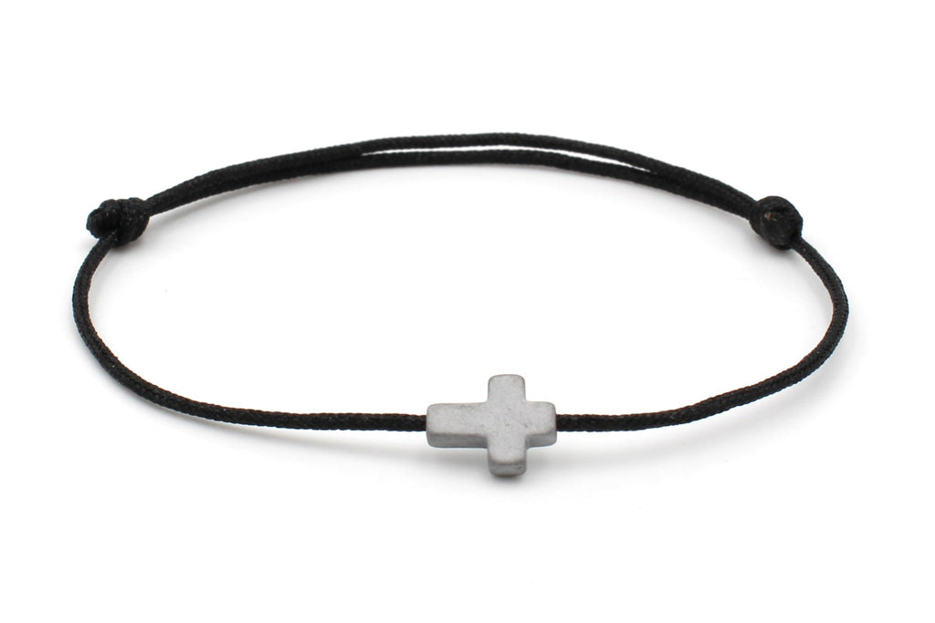 schwarzes Kreuz Armband mit Schiebeknoten Verschluss auf weißem Hintegrund