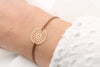 braunes Armband mit Blume des Lebens in rosegold am Handgelenk getragen