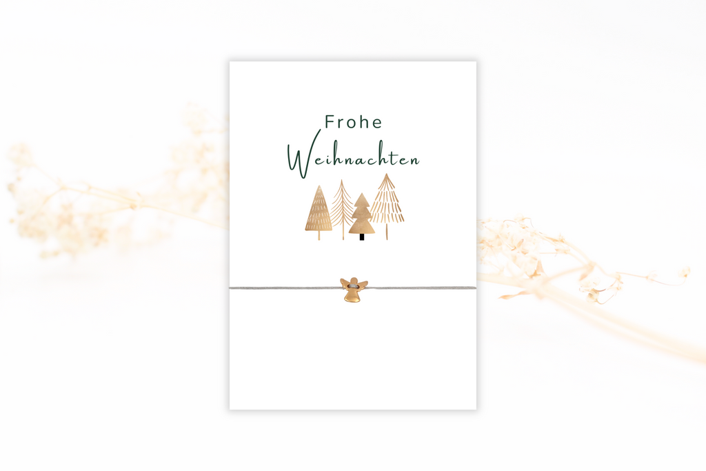 Frohe Weihnachten Karte mit beigen Tannenbäumen als Motiv und grauem Schutzengel Armband