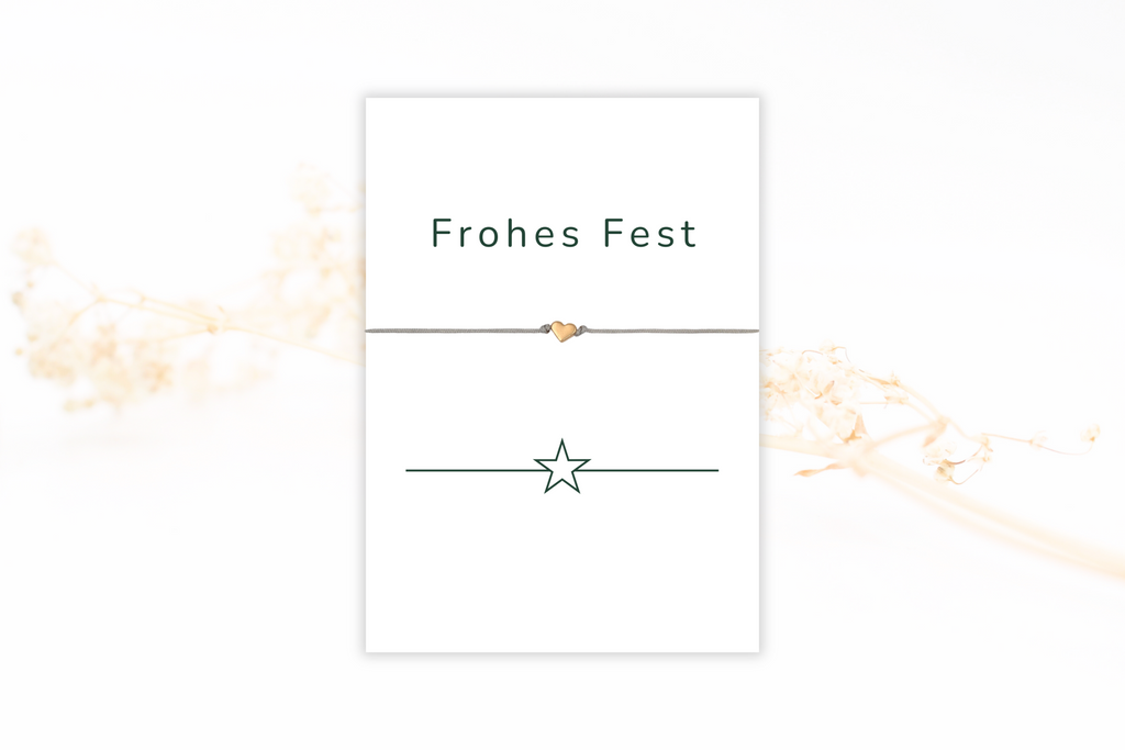 Karte Frohes Fest mit grünem Stern Motiv und einem grauen Armband mit rosegoldfarbenem Herz