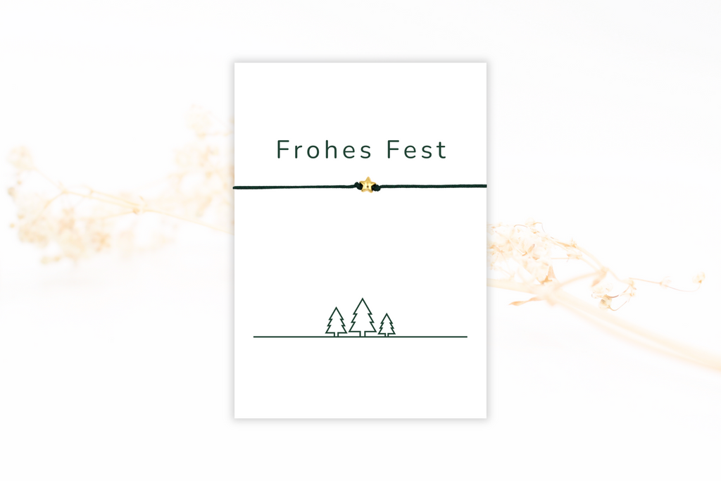 Karte Frohes Fest in weiß mit Grünen Tannenbäumen als Motiv und einem Schiebeknoten Armband mit Stern in gold