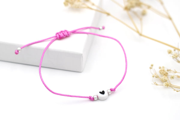 rosa Makramee Herzarmband mit weiß schwarzer Herzperle und silberfarbenen kleinen Metall Perlen, Verschluss geflochtener Makramee Verschluss