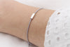 hell graues Tube Armband aus Leder mit silbernem Rechteck am Handgelenk getragen