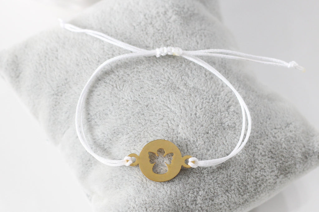 Armband mit goldfarbenem Engel aus Edelstahl und weißem Makramee Band, perfekt als Kommunion Geschenk für Mädchen