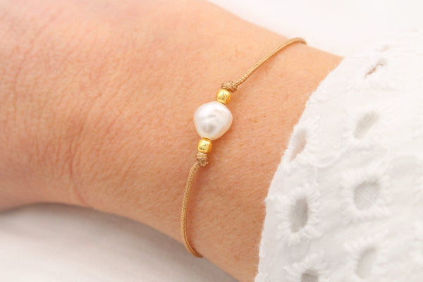 Beiges Perlenarmband mit einer Süßwasserperle und 925 Silber Perlen am Handgelenk der Dame getragen
