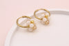 Details der creme-goldfarbenen Edelstahl Ohrringe in Blumenform