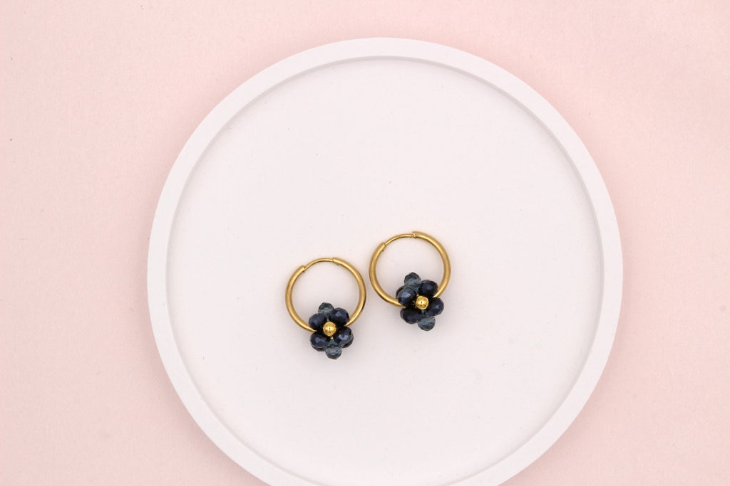goldfarbene Creolen mit funkelndem Blumenanhänger in blau