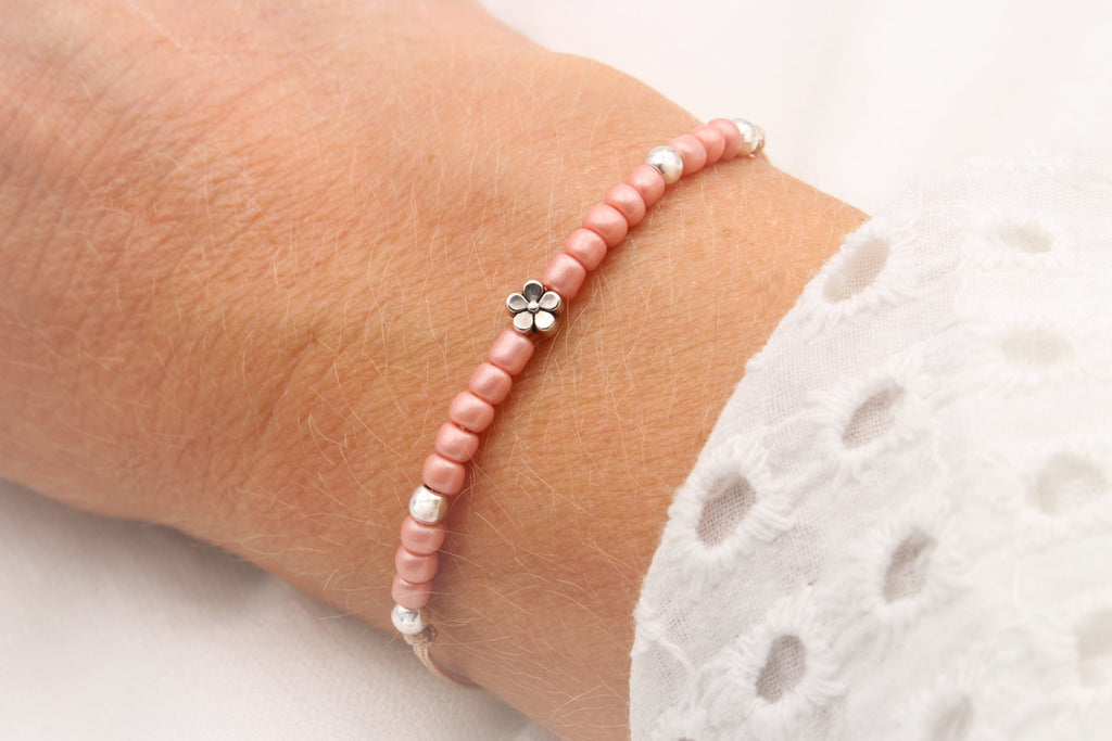 Blumenkind Armband in Rose mit silberfarbener Blume am Handgelenk des Kindes getragen