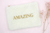 trendige Kosmetiktasche Teddy Style in beige mit gesticktem Aufdruck Amazing in goldfarben