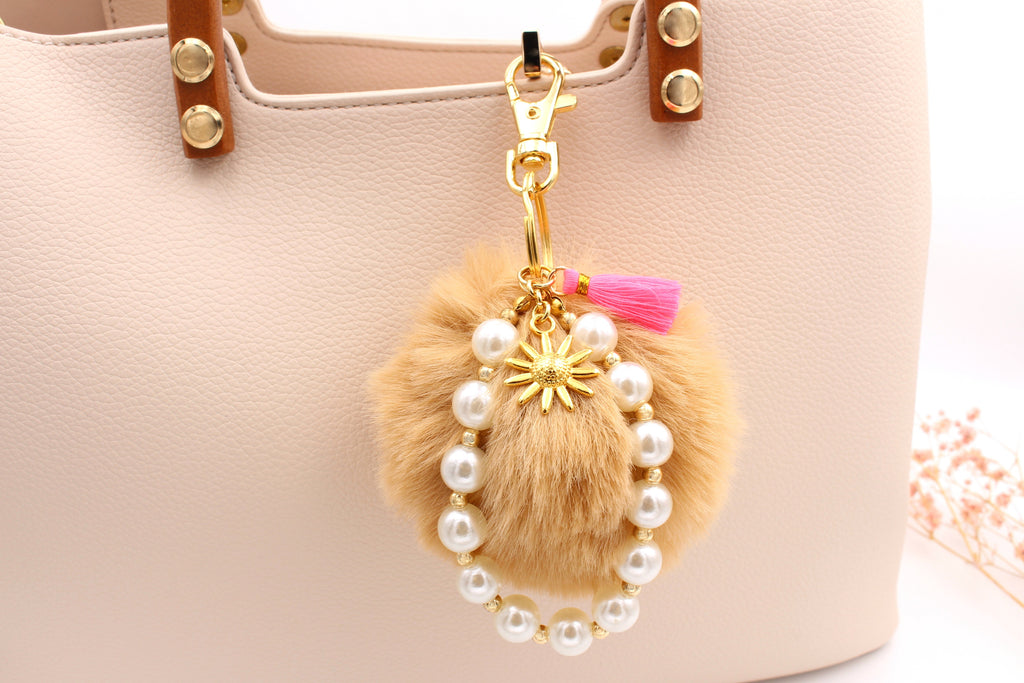 süßer Taschenanhänger mit Pompon und kleinen Details in goldfarben