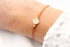 oranges Schulkind Armband mit weißer Herzperle am Handgelenk getragen