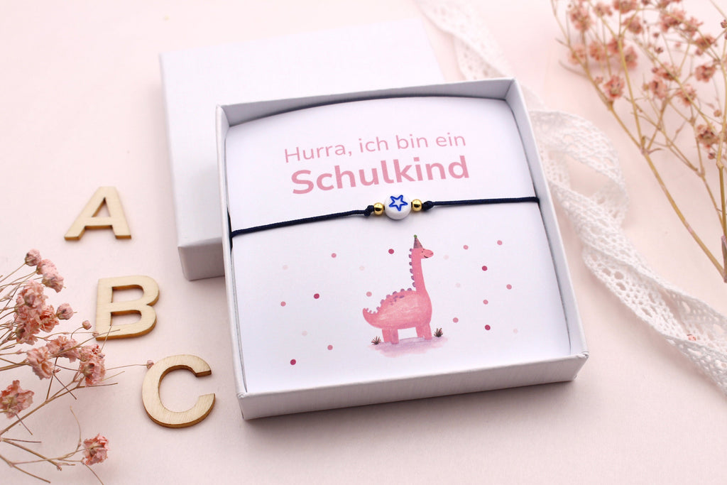 rosa Dino Karte mit Armband für das Schulkind als kleine ausgefallene Geschenkidee zum Schulstart