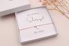 graue Schutzengel Karte mit Text "Ein kleiner Schutzengel für dich", passend mit Schutzengelarmband, verpackt in einer weißen Schmuckschachtel