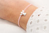 Rosa Schutzengel Armband mit silberfarbenem Schutzengel Anhänger am Handgelenk der Frau getragen