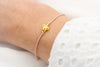 Turtle Armband mit kleiner Schildkröte in golfarben und rosegoldfarbenem Makrameeband am Handgelenk der Dame getragen