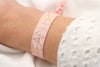 Team Bride elastisches Armband in rosa mit goldfarbener Schrift auf Handgelenk