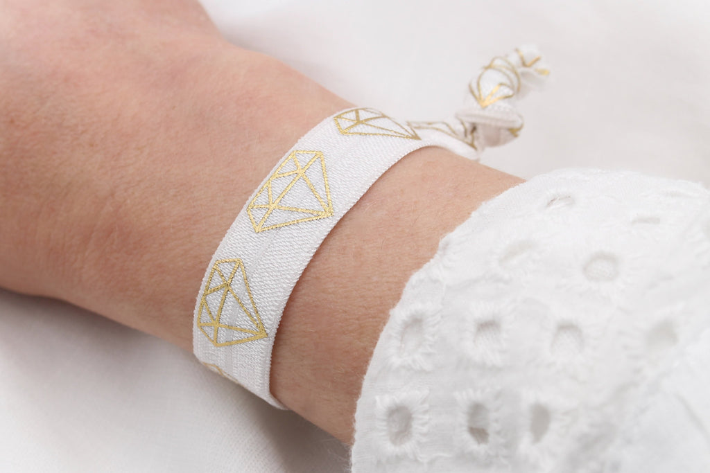 Elastisches Armband weiß mit gold am Handgelenk der Brautjungfer