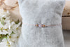 verstellbares Makramee Armband mit Perle Rosenholz Farbe rosegold, silber oder gold auf einem grauen Kissen